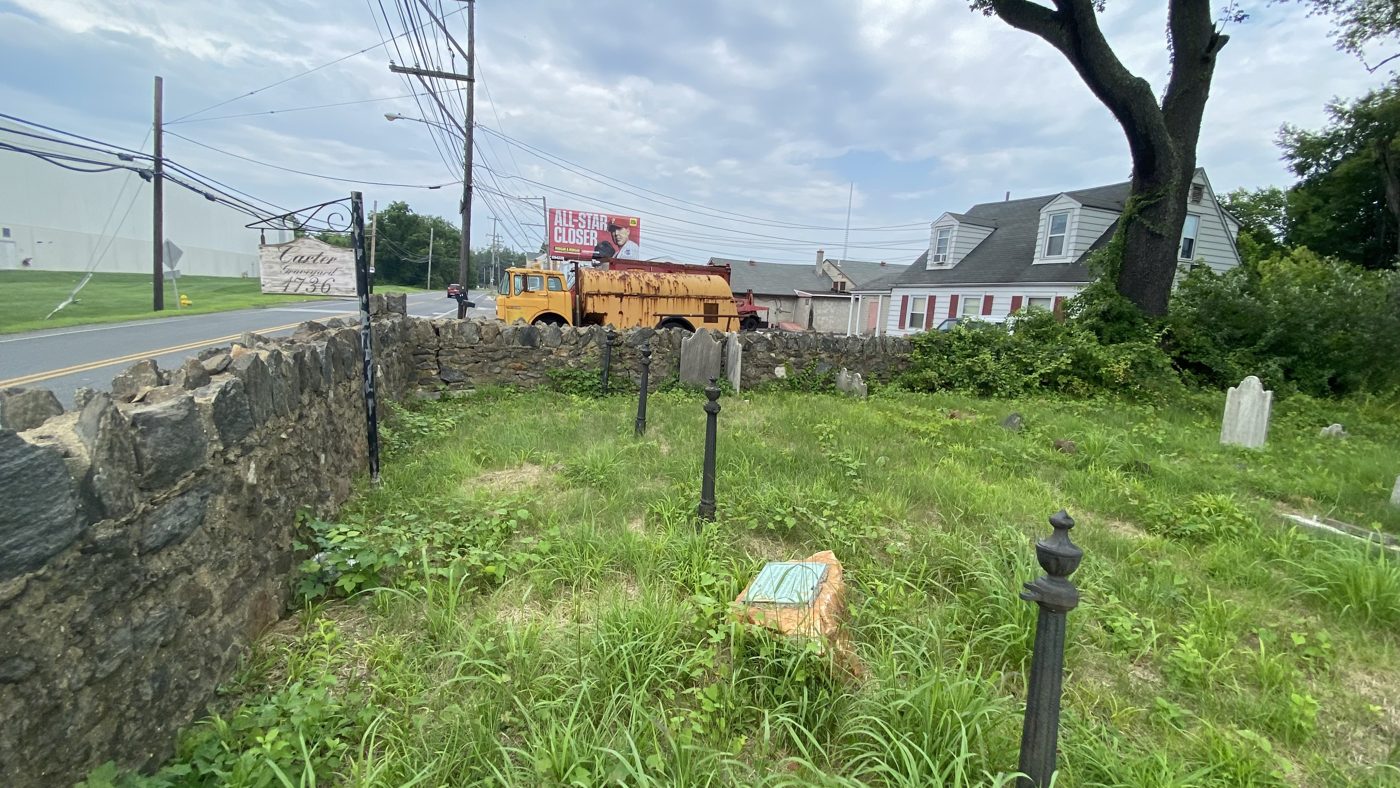 Graveyard interior with the stone wall along Concord Road, iron posts and low markers
